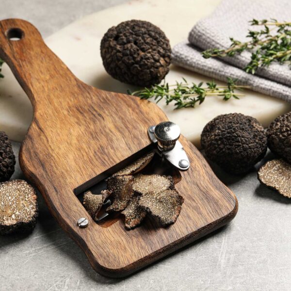 Fresh black truffles, slicer and thyme on grey table